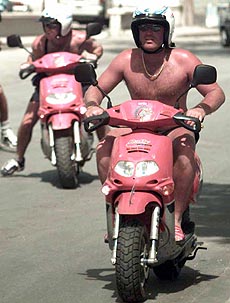 Australian top spin bowler Shane Warne (right) rides on a scooter during an island tour in Bridgetown, Barbados, on Thursday. Warne and other Australian team members have spent the last two days touring the island