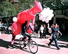 A giant rubber kangaroo mounted on a bicycle follows a balloon carrier through the center of downtown Sydney, Australia on Tuesday, to mark 500 days to go until the opening ceremony of the Sydney 2000 Olympic Games 
