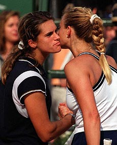 Mary Pierce of France (right) kisses fellow Frenchwoman Amelie Mauresmo at the end of their Italian Open women's clay-court tennis tournment semifinal match