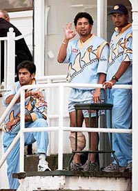 Sachin Tendulkar (centre) signals he is fine to a supporter