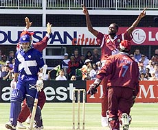 Scotland's cricket captain George Salmond makes the walk back to the pavilion after West Indian bowler Curtly Ambrose (centre) dismissed him at Leicester County Cricket club, in the Midlands, England, on Thursday
