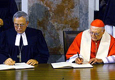 Christian Krause, left, president of the Lutheran World Federation, and Edward cardinal Cassidy, president of the Pontifical Council of Christian Unity sign the Joint Declaration on the Doctrine of Justification in Augsburg, Germany, Sunday. 
