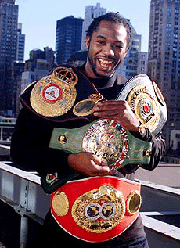 Lennox Lewis, the undisputed world heavyweight boxing champion, shows off his four belts in New York, on Wednesday afternoon