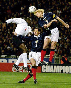 England's Sol Campbell, left, leeps to win posession of the ball from Scotland's Colin Hendry, right, over Scotland's David Weir, center, during their European Championship play-off second-leg soccer match at London's Wembley stadium on Wednesday