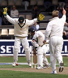 Australia's Shane Warne, right, celebrates bowling Pakistan's Mahmood, center, during their cricket test in Hobart on Thursday