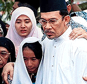 Malaysia's jailed politician Anwar Ibrahim, right, embraces his daughter Nurul Ilham, centre, and Nurul Hana, bottom, while Nurul Izzah, top, crying during funeral ceremony of Anwar's eldest brother Rani Ibrahim in Kuala Lumpur on Sunday. 