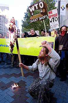 A man burns a pair of GAP pants while protesting the upcoming World Trade Organisation conference in downtown Seattle on Sunday