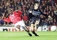 Manchester United's Andy Cole shoots past Marseilles Yannick Fischer, at United's Old Trafford Stadium, in Manchester, England