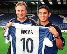 Britain's first footballer to be signed from India Baichung Bhutia (right) holds his new teams shirt as he stands alongside Bury Town's manager Neil Warnock