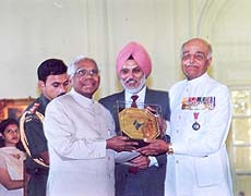 President K.R.Narayanan presenting a golden trophy to Air Chief Marshal (retd) O.P.Mehra as Major General (retd) S.S.Sandhu looks on at a function organised at Rashtrapati Bhavan on Friday to celebrate International Day of Older Persons with Helpage India. 