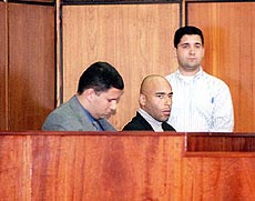 The son of former Brazilian soccer star Pele, Edson Cholbi do Nascimento, centre, sits in a courtroom during their trial in Santos on Tuesday