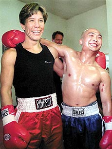 Boxers Margaret MacGregor (left) and Loi Chow smile for the cameras in Seattle, Wash., on Tuesday. The two will not share such pleasant exchanges when they meet in the ring in the first male/female fight on Saturday