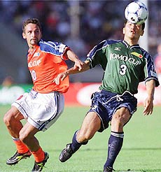 Inter Milan star striker Roberto Baggio (10) of the foreign players' team battles for the ball with Yutaka Akita of the Japanese selection team during the JOMO Cup