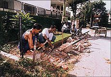 Labourers dismantle angle irons outside a house at Sector 8 in Panchkula on Tuesday following notices about removal of encroachments received by the occupants.