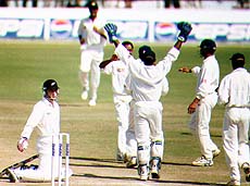 Indian fielders congratulating fellow spinner Sunil Joshi for getting New Zealand batsman C. Spearman caught by Saurav Ganguly at the slips on the final day of the first test between India and New Zealand, at the PCA stadium in Mohali on Thursday