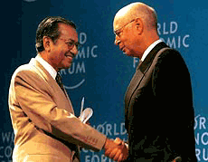 Klaus Schwab, founder and president of World Economic Forum, congratulates Malaysian Prime Minister Mahathir Mohamad for his keynote address at the East Asia Summit 
