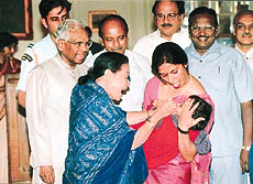 The First Lady, Mrs Usha Narayanan, administers pulse polio drop to a child while President K. R. Narayanan looks on