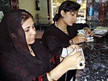 Women count money at a money exchange shop in Islamabad, as foreign exchange bureaus resume trading on Monday.