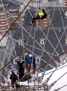 An unidentified Spanish environmental protestor, abeils down to the centre cog of the Millennium Wheel on the south bank of the River Thames in London on Tuesday, after spending 30 hours on the lofty perch.