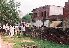 A group of "helpers"pass cheating material to their wards and friends through police personnel during the supplementary exams at Government High School, Dera Bassi, on Saturday.