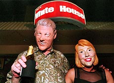Kees Weening, a Dutch businessman (left) puts on the mask of US President Bill Clinton while a Thai girl (right) wore the mask of Hillary Clinton outside the White House bar in downtown Bangkok on Tuesday. The duo tried to attract customers at a newly opened entertainment plaza. 
