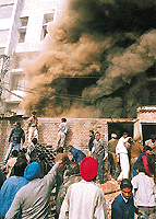 Smoke rises out of the showroom even as onlookers try to make an entry into the basement in Sector 9, Panchkula.
