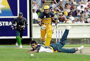 Pakistani bowler Abdur Razzaq, foreground, watches the ball roll away after he misfielded off his own bowling to Australian batsman Ricky Ponting (centre) in yellow, during the one day international at the Melbourne cricket ground, Melbourne, Australia on Sunday