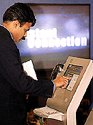 A visitor tries out an MTNL instant Internet connection terminal at "IT Asia 2000", in New Delhi. — AFP 
