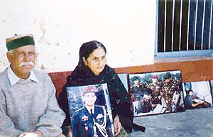 Major Sudhir’s parents with a photograph of his at their home in Banuri village