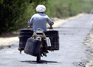 Not the milkman, but a villager bringing containers filled with drinking water atop his motorcycle for his family from a town several kilometres away in Rajasthan
