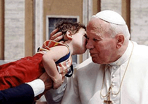 Pope John Paul II is kissed by a little child as he tours St. Peter's Square at the Vatican prior to the start of an outdoor general audience on Wednesday