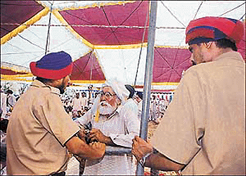 Policemen stop an old man from meeting the Chief Minister at Dhamot village in Ludhiana district on Friday.