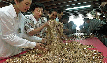 Thai foundation volunteers check gold jewellery given to Buddhist monks by Thai people in an effort to help the central bank refill the countrys gold reserves on Wednesday, before the gold is sent for refining into bars.  AFP photo