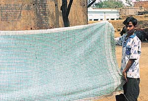 Jamil Mohammed displays the cotton blanket woven by him.
