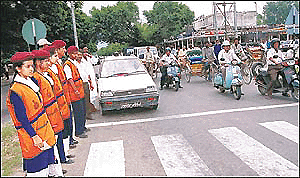 Schoolchildren, who are members of the National Social Service (NSS), manning traffic in Sector 22 in Chandigarh on Thursday.					    Tribune photo by Manoj Mahajan