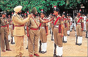A police official explains a point to a woman constable at the full dress rehearsal in Chandigarh Parade Ground in Sector 17 on Saturday.  A Tribune photo