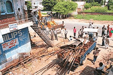 A tractor-load of material being taken away after an anti- encroachment drive at Attawa village.