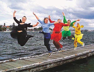 Colourful performers dance during celebrations marking the arrival of the Olympic flame in Sydney
