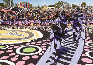 Colourful performers dance during celebrations marking the arrival of the Olympic flame in Sydney