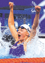 Megan Quann of the USA raises her fists after winning the gold medal in the womens 100m breaststroke.