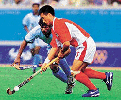 South Korea's Kim Chel-Hwan (5) controls the ball as India's Dhanraj Pillay chases during the men's preliminary hockey match at the Olympic Games in Sydney on Thursday. Korea won the match 2-0.  Reuters Photo