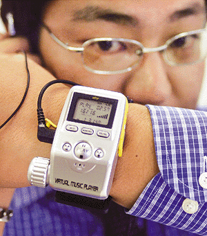 NH Japan Holdings Ltd (NHJ) Chief Operations Officer Shinji Ogata shows off the V@mp MP3 wrist music player in Tokyo