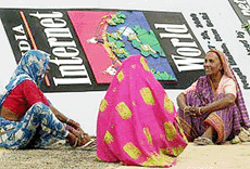 Women workers take a break on Tuesday in front of a banner during preparations for India Internet World Show 2000 beginning on Wednesday. 