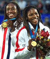 Venus (R) and Serena Williams celebrate on the podium after the gold medal match in the women's doubles of the Olympics in Sydney on Thursday. The Williams sisters defeated Kristie Booggert and Mirian Oremans of the Netherland 6-1, 6-1. 