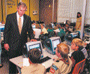 Republican presidential candidate and Texas Governor George W. Bush stops to talk to students in a computer lab during a tour of a primary school in Beaverton