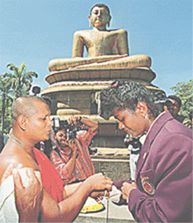 A Buddhist monk (L) blesses Susanthika Jayasinghe (R) as she returns home to Colombo on Tuesday after winning a bronze medal in the womens 200m event, at the Sydney 2000 Olympics Games