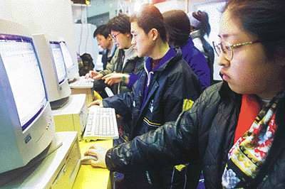 Visitors to a computer exhibition surf the Net in this file photograph