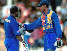Sri Lankan batsman Russell Arnold (R) congratulates Sri Lankas captain Sanath Jayasuriya after he scored a century against India during the Sharjah triangular tournament final on Sunday.