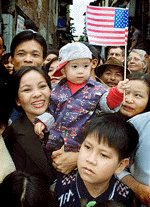 A young boy holding a U.S. flag is surrounded by fellow Vietnamese trying to get a glimpse of President Clinton in Hanoi on Saturday.