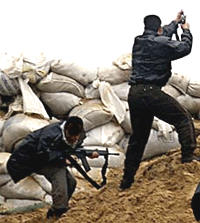 Palestinan gunmen shoot from a sandbagged position at Khan Younis in the Gaza Strip during an exchange of fire with Israeli troops on Thursday